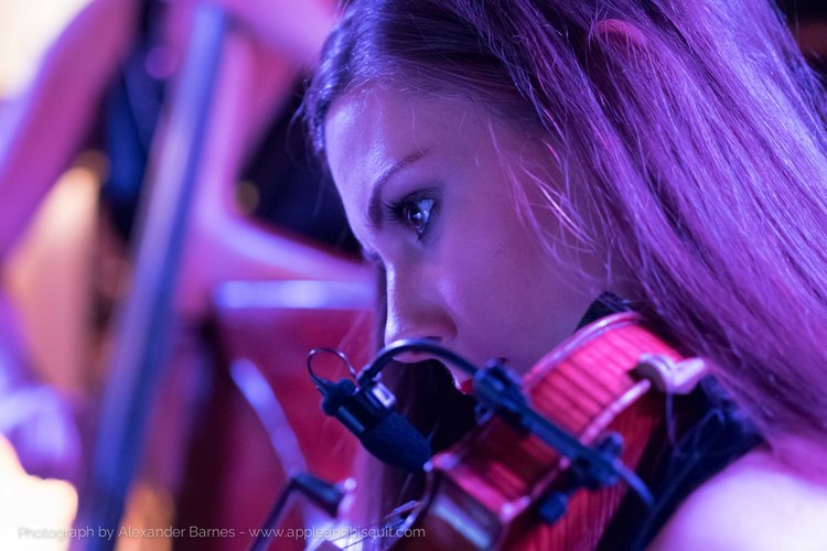Close up of one of our Blue Topaz violinists performing with an instrument microphone, demonstrating our sound enhancement and amplification services